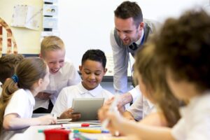 A male Primary school teacher working with a small group